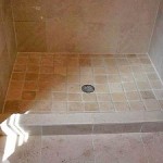 Hand cut and installed travetine tiles give this shower an old world appearance